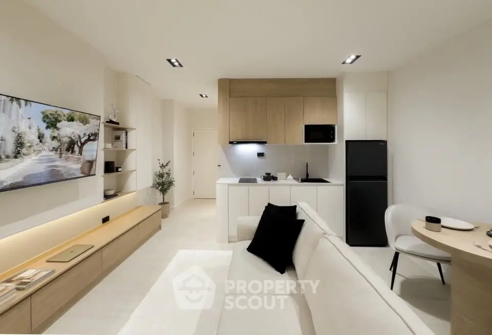 Modern open-plan living room with sleek kitchen and cozy seating area, perfect for contemporary urban living.