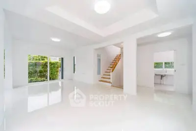 Spacious modern living room with sleek staircase and large windows