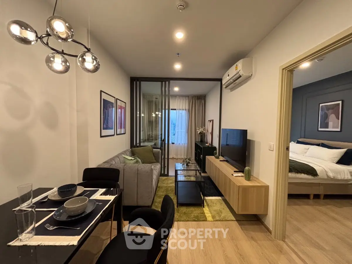 Modern living room with stylish decor and open layout leading to a cozy bedroom.