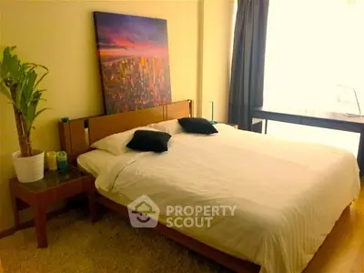 Cozy bedroom with modern decor and large window for natural light.