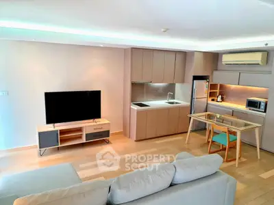 Modern open-plan living room with sleek kitchen and cozy seating area, perfect for urban living.