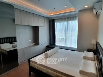 Modern bedroom with large window and built-in wardrobe in luxury apartment