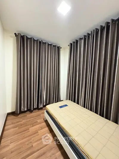 Cozy bedroom with wooden flooring and elegant curtains