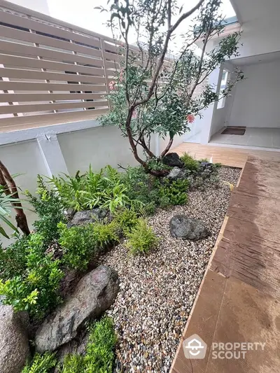 Beautifully landscaped garden with lush greenery and rocks in a modern outdoor space.