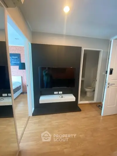 Modern apartment interior with sleek TV setup and wooden flooring