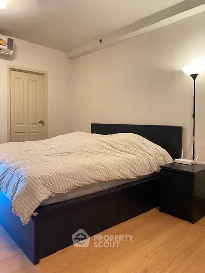 Cozy bedroom with modern furniture and warm lighting, perfect for relaxation.