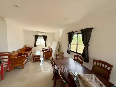 Spacious living and dining area with elegant wooden furniture and natural light.