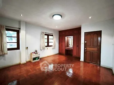 Spacious bedroom with wooden flooring and built-in wardrobe