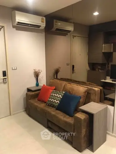 Cozy living room with stylish sofa and modern air conditioning units, perfect for relaxation.