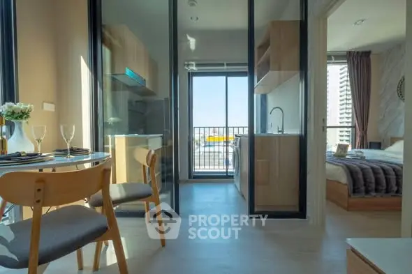 Modern apartment with open kitchen and balcony view, featuring stylish dining area and cozy bedroom.