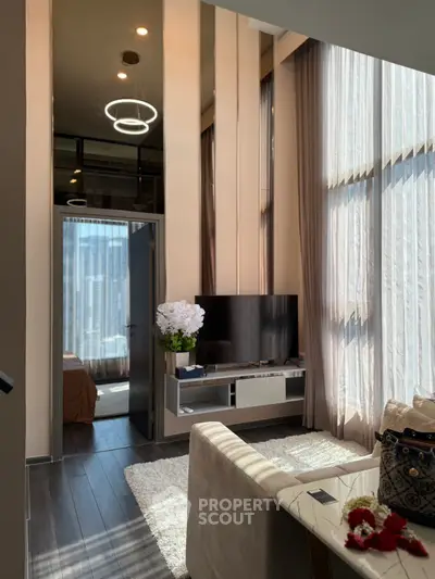 Luxurious modern living room with high ceilings and large windows offering stunning city views.