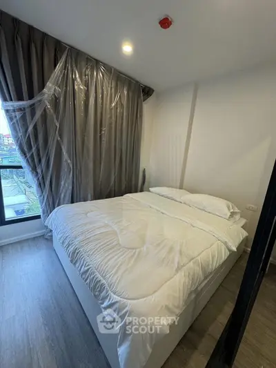 Modern bedroom with large window and elegant curtains in a stylish apartment.