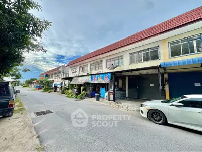 Charming suburban street view with row of townhouses and parked cars, ideal for family living.
