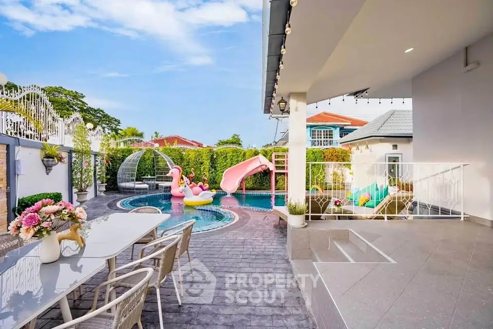 Luxurious outdoor pool area with slide and seating, perfect for entertaining and relaxation.