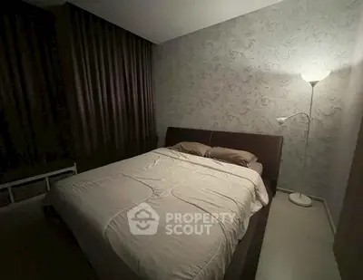 Cozy bedroom with elegant wallpaper and soft lighting, perfect for relaxation.