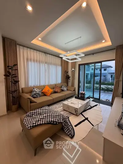 Luxurious modern living room with elegant decor and large windows offering a stunning view of the outdoors.