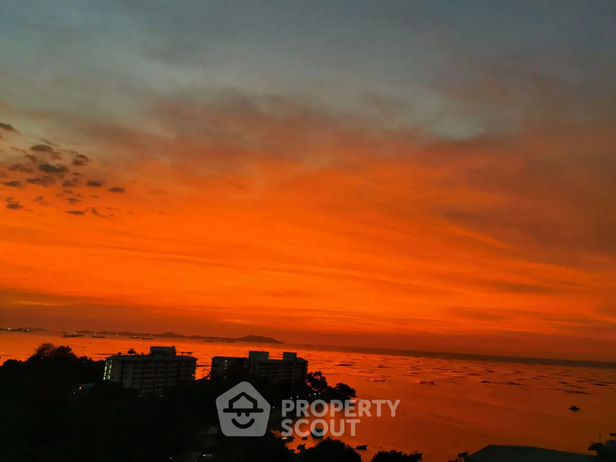 Stunning sunset view over coastal buildings with vibrant orange sky