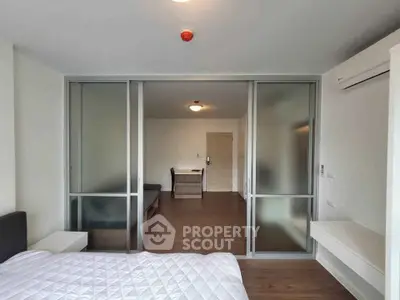 Modern studio apartment with sliding glass doors and wooden flooring