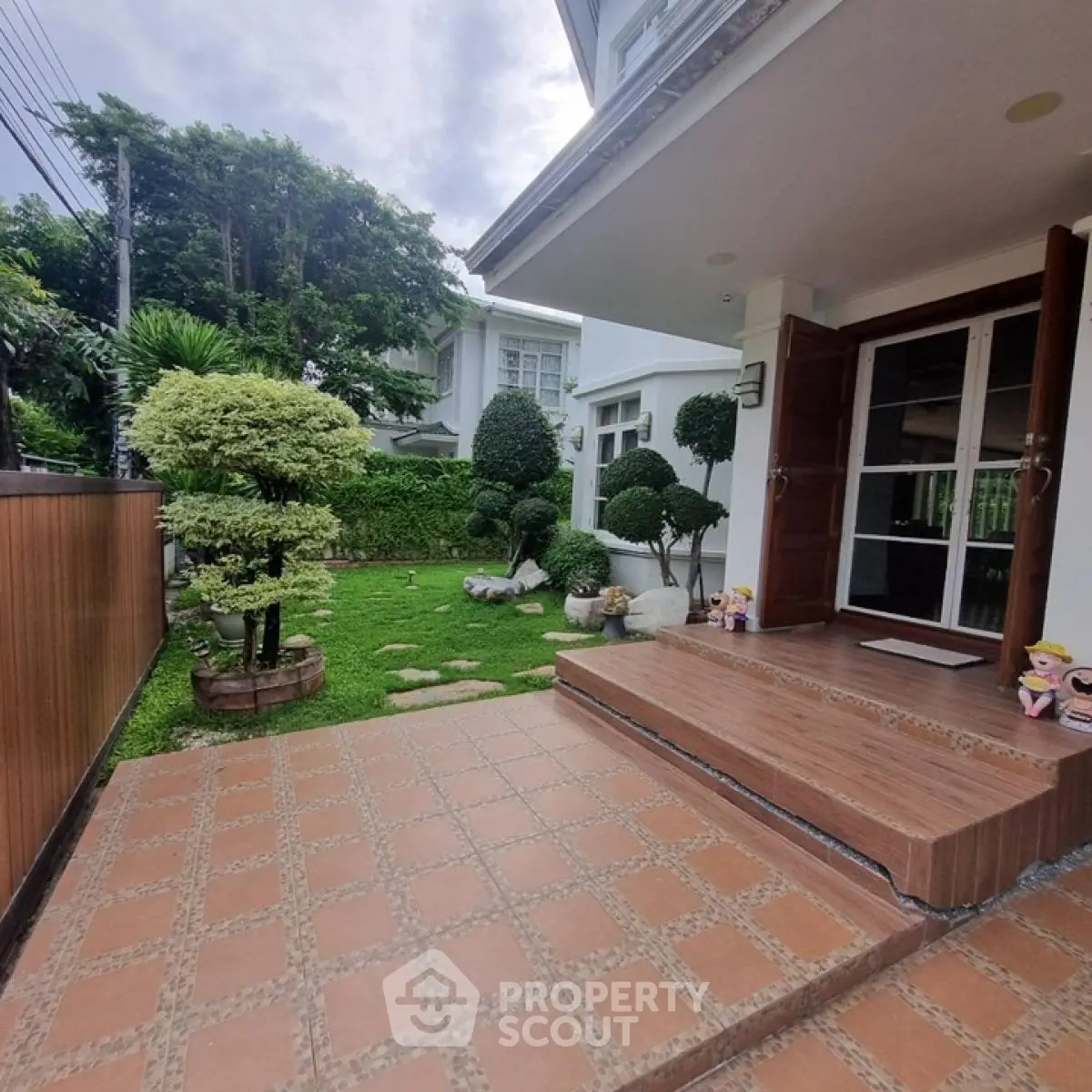 Charming garden entrance with lush greenery and elegant steps in a modern home