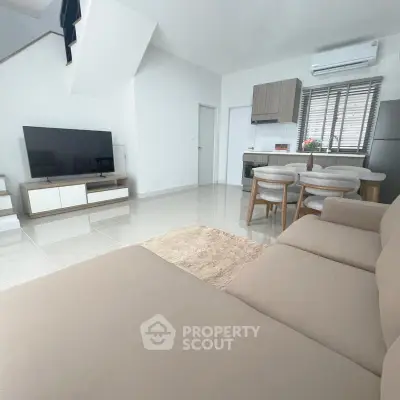 Modern living room with sleek furniture and open kitchen layout, perfect for contemporary living.