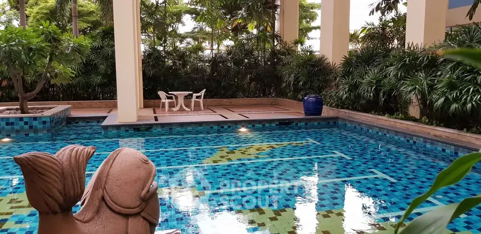 Luxurious swimming pool area with lush greenery and elegant design, perfect for relaxation and leisure.