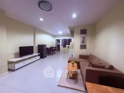 Spacious living room with modern furniture and open layout, perfect for relaxation and entertainment.