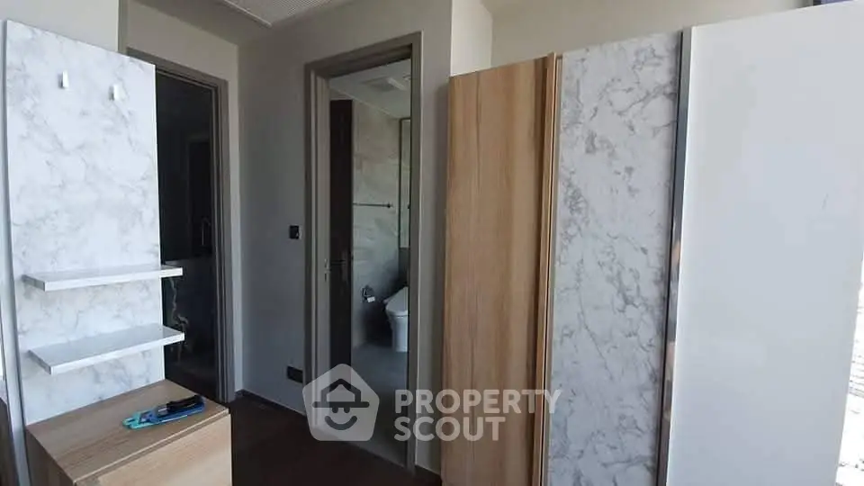 Modern interior with marble accents and wooden cabinetry in a sleek bathroom setting.