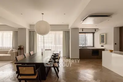 Spacious modern living room with dining area and open kitchen, featuring elegant wooden flooring and stylish decor.