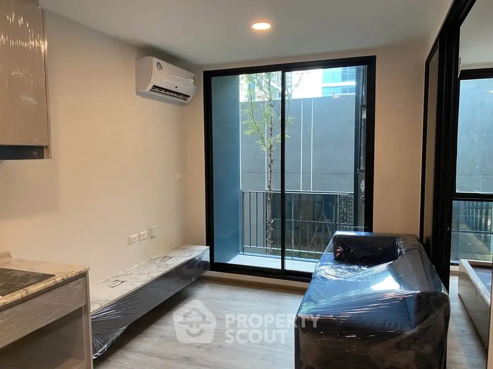 Modern living room with sleek design and balcony access in urban apartment.