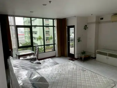Spacious living room with large windows and modern furnishings in urban apartment
