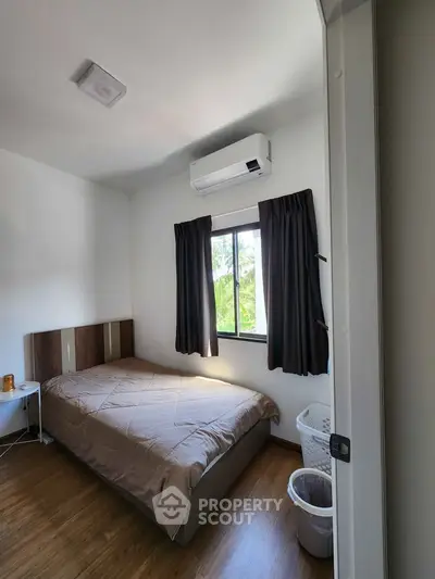 Cozy bedroom with air conditioning and natural light, perfect for relaxation.