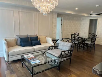 Elegant living room with hardwood floors, stylish furniture, and a stunning chandelier.