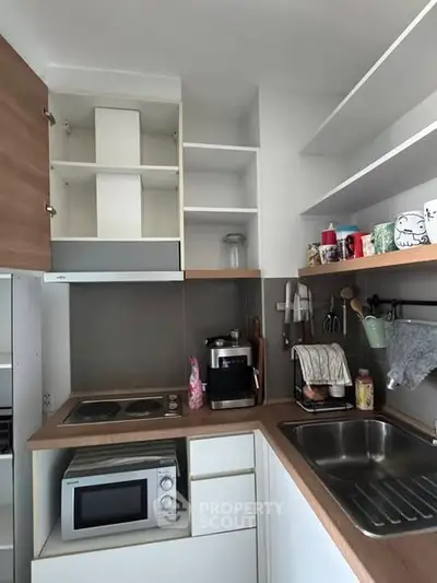 Modern compact kitchen with sleek appliances and open shelving