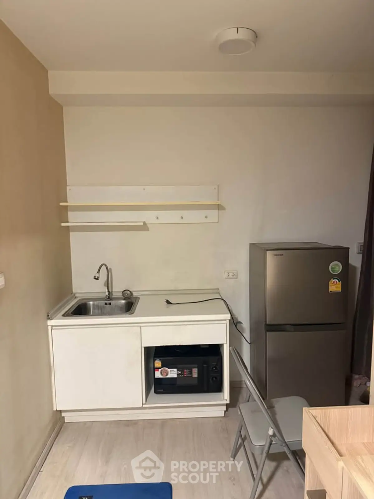 Compact kitchen with fridge and sink in modern apartment