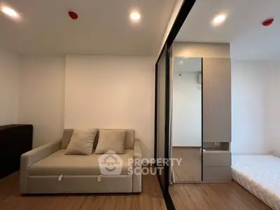 Modern apartment interior with cozy sofa and sliding door to bedroom