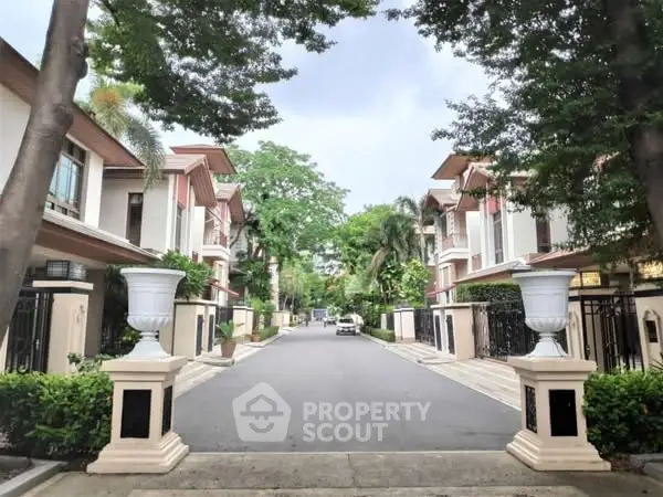 Luxurious gated community entrance with lush greenery and elegant architecture