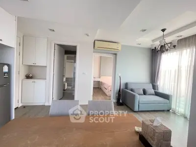 Modern open-plan living room with dining area and cozy bedroom view.