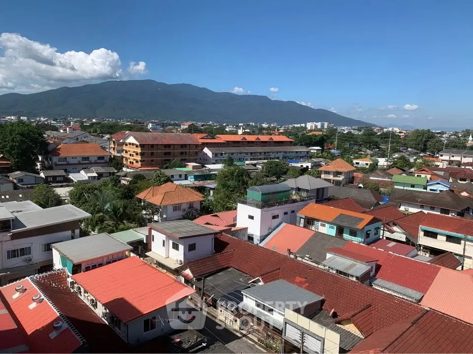Scenic aerial view of residential neighborhood with mountain backdrop and clear blue sky.