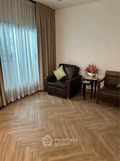 Cozy living room with elegant parquet flooring and stylish seating area.