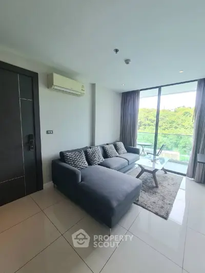 Modern living room with large windows and scenic view, featuring a stylish sofa and sleek decor.