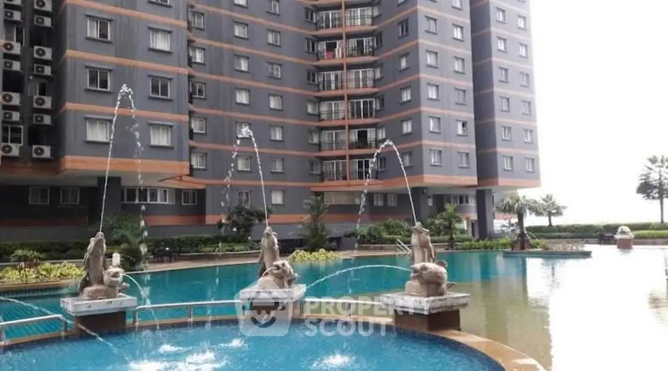 Luxurious apartment building with stunning pool and elegant water features.