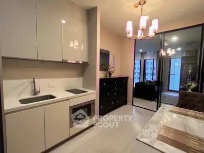 Modern kitchen with sleek cabinetry and dining area in stylish apartment