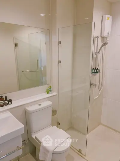 Modern bathroom with glass shower and sleek fixtures in contemporary apartment.