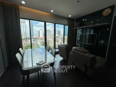 Modern living room with city view, featuring sleek furniture and large windows.