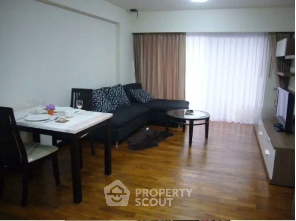 Modern living room with wooden flooring, cozy sofa, and dining area in open layout apartment.