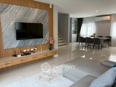 Modern living room with sleek TV setup and elegant dining area