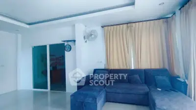 Spacious living room with modern blue sofa and elegant curtains