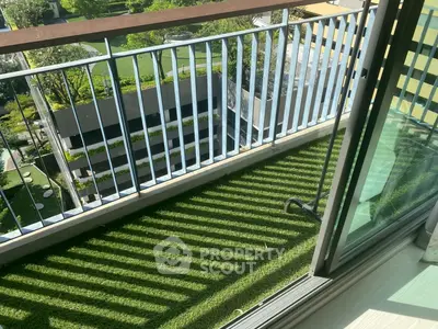 Charming balcony with artificial grass and scenic view of lush greenery, perfect for relaxation and outdoor enjoyment.