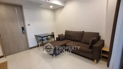 Modern living room with cozy brown sofa and dining table in a stylish apartment.