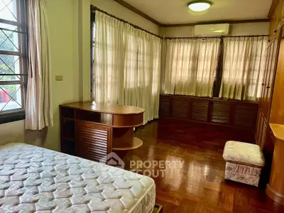 Spacious bedroom with wooden furniture and natural light